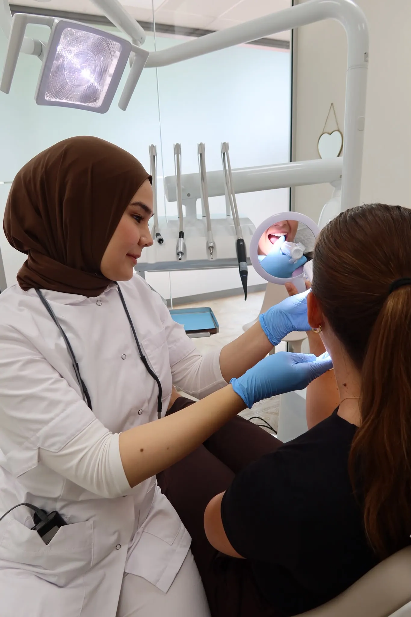 Mondhygiënist Nagihan behandelt een patiënt in de behandelkamer